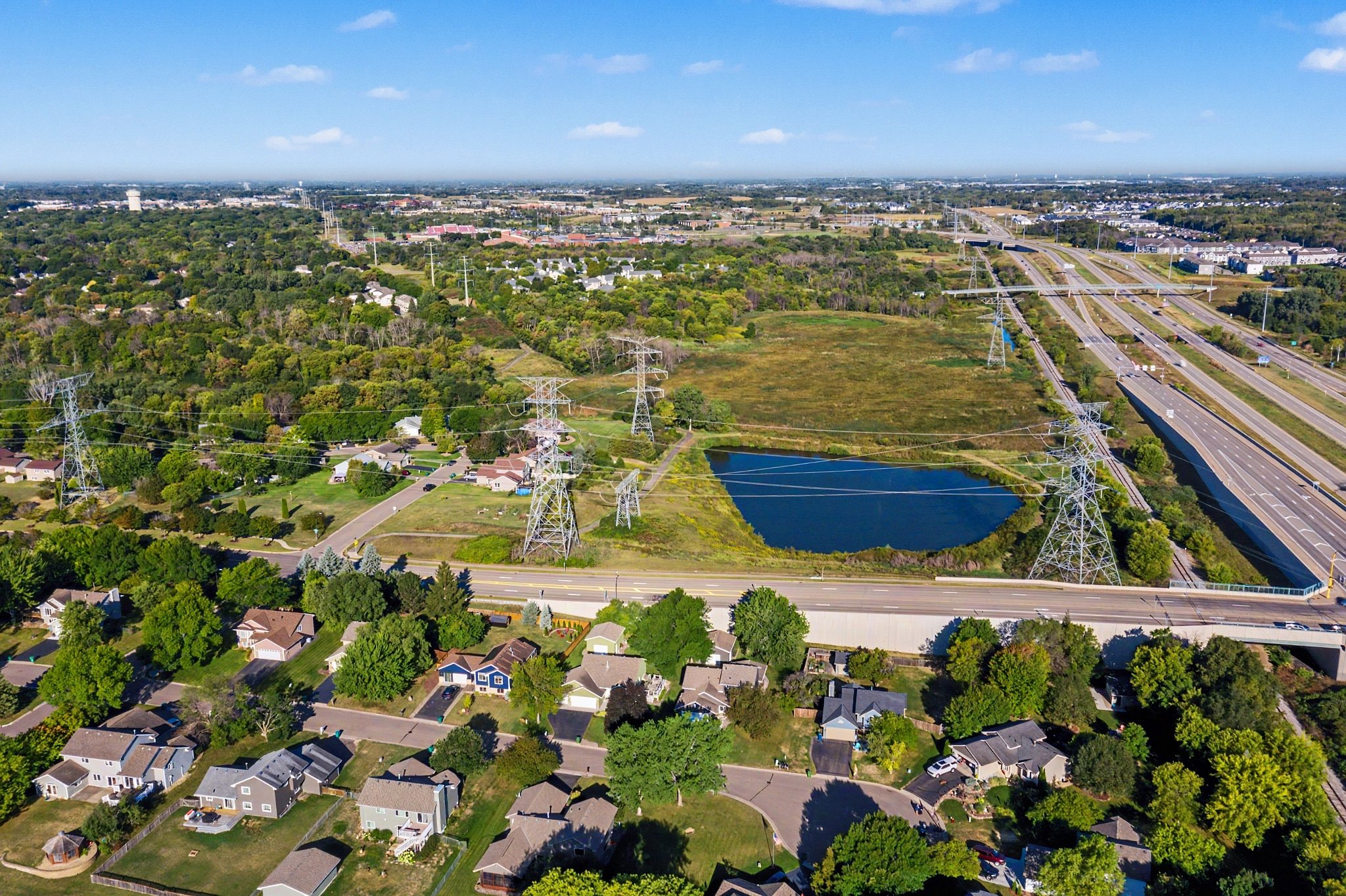 An aerial photograph over Maple Grove, Minnesota, with the listed home, a school and a retailer labeled at their real positions and distances.